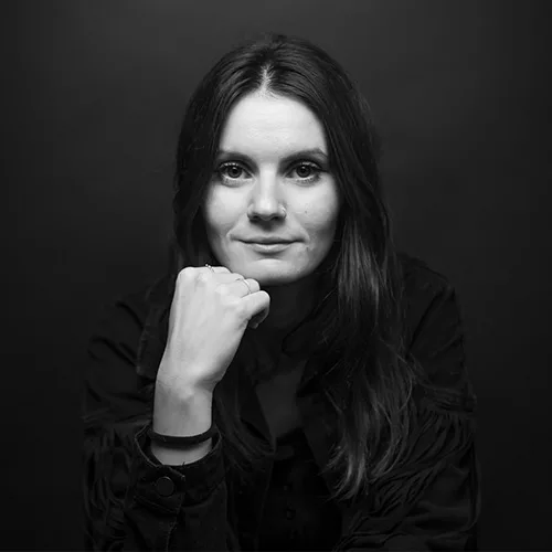 Photographie de portrait par Photographe Poitiers -  Photo prise au studio d'une jeune femme posant avec la main sous le menton en noir et blanc